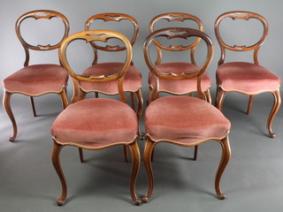A set of 6 Victorian carved rosewood spoon back dining chairs, the seats of serpentine outline, raised on cabriole supports 