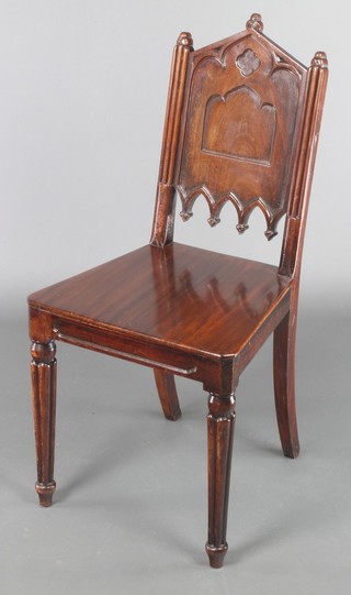 A Victorian mahogany Gothic style hall chair with solid seat raised on turned and reeded supports