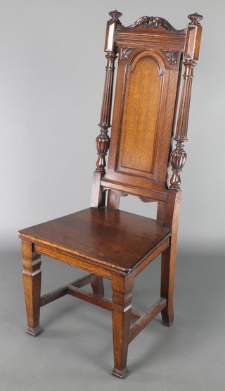 A Victorian carved oak hall chair with solid seat and fluted columns to the side, raised on square tapering supports 