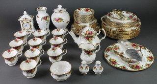 A Royal Albert Old Country Roses tea and dinner service, comprising 8 tea cups and 8 saucers, a teapot, cake stand, cake slice, 2 tier cake stand, timepiece, pair of condiments, 2 vases, milk jug, sugar bowl, 10 dinner plates, 10 medium plates, 8 small plates and a dish 
