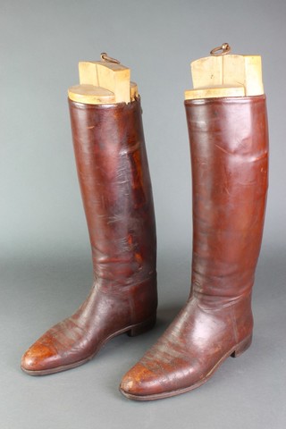A pair of brown leather riding boots with trees 