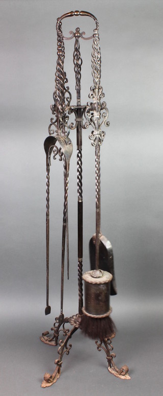 A wrought iron 4 piece fireside companion set comprising shovel, poker and tongs 