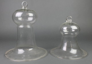 Two clear glass bell shaped scientific vessels