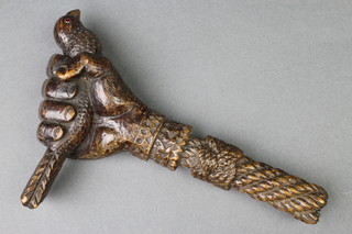 A Victorian carved hardwood parasol handle in the form of a clenched fist grasping a bird, the bird's eyes set hardstones  6"
