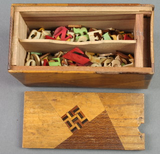 An Oriental hardwood box with secret locking mechanism containing approx. 330 carved ivory and other letters 