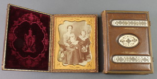 An early 19th Century black and white family portrait photograph 6" x 4" contained in a leather frame and a Victorian leather bound photograph album 
