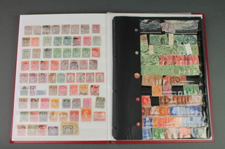 A red stock book containing 12 penny reds and various used GB stamps, George VI and QEII