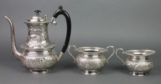 An Indian repousse silver 3 piece tea set  with ebony mounts, profusely decorated with figures and animals in landscapes, gross 1650 grams