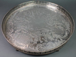 A circular silver plated galleried tray on claw and ball feet 22" 