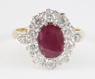 An 18ct yellow gold ruby and diamond cluster ring, the centre oval stone approx. 2.50ct surrounded by 12 brilliant cut diamonds approx. 1.30ct, size P 