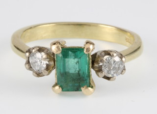 An 18ct yellow gold emerald and diamond ring, the rectangular cut emerald flanked by 2 brilliant cut diamonds, size L 1/2