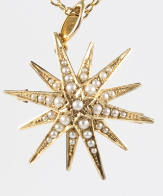 An Edwardian 15ct seed pearl set star pendant/brooch on a gold chain 