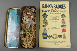 A quantity of Second World War and other cap badges together with a rank and badge booklet 