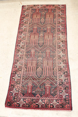 A red ground rug with panel decoration and geometric design within multi-row borders 119" x 49" 