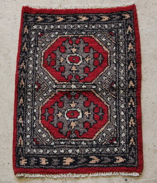 An Afghan red and white ground slip rug with 2 octagons to the centre 36" x 25" 