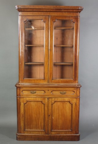 A Victorian mahogany bookcase on cabinet with moulded cornice, the upper section fitted shelves enclosed by glazed panelled doors, the base fitted 1 long drawer above a cupboard enclosed by panelled doors 81"h x 41"w x 19"d 
