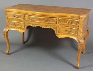 A walnut writing table of serpentine outline fitted 1 long and 4 short drawers, raised on carved cabriole supports 30"h x 48"w x 22"d 