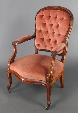 A Victorian show frame mahogany open arm chair upholstered in pink buttoned back dralon, raised on cabriole supports 