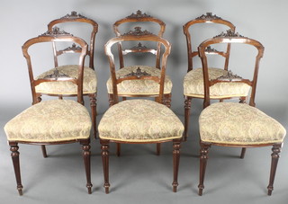 A set of 6 Victorian walnut bar back dining chairs with carved mid rails and upholstered seats, raised on turned and fluted supports 