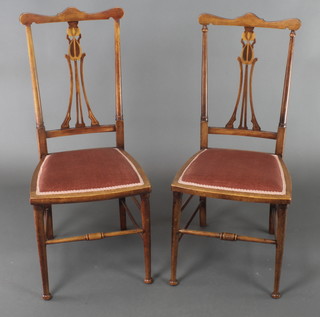 A pair of Art Nouveau inlaid mahogany slat back bedroom chairs with upholstered seats, raised on turned supports