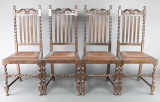 A set of 4 1930's carved oak stick and rail back dining chairs with spiral turned decoration and upholstered seats, raised on turned and block supports