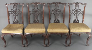 A set of 4 Edwardian carved mahogany Chippendale style dining chairs with vase shaped slat backs, over stuffed seats, raised on French cabriole supports 
