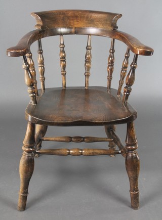 An elm smokers bow chair with bobbin turned decoration and solid elm seat, raised on turned  supports with H framed stretcher