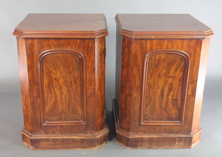 A pair of Victorian mahogany pedestals, the interiors fitted shelves and a drawer enclosed by arched panelled doors and with chamfered corners 31"h x 23"w x 22"d 