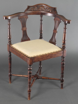 An Edwardian carved walnut corner chair with pierced vase shaped slat back raised on turned supports