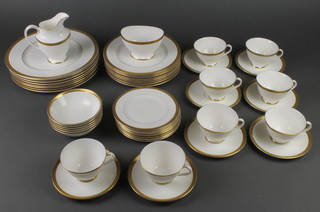 A Royal Doulton Royal Gold pattern tea and dinner service comprising 8 tea cups, 8 saucers, 8 dinner plates, 8 side plates, 9 sandwich plates, 6 dessert bowls, a milk jug and sugar bowl 