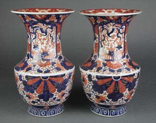 A pair of late 19th Century Imari baluster vases with waisted necks decorated with panels of flowers on a formal scrolling floral ground 14 1/2" 