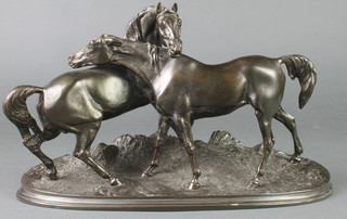 A bronze figure group of a standing Arab stallion and mare, raised on an oval naturalistic base 7", the base marked SS 021 