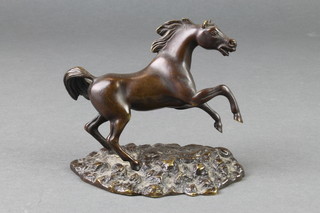 A bronze figure of a rearing stallion, raised on an oval base 4 1/2" 