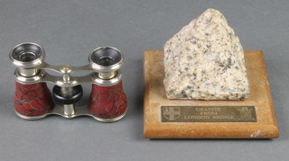 A pair of gilt metal opera glasses together with a section of granite removed from the old London Bridge now in the form of a paperweight 