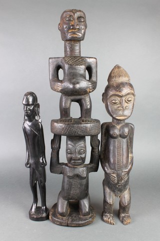 A carved African hardwood figure of 2 standing gentleman 27 1/2", some old and treated worm, 1 other figure of a standing lady 22" and 1 other of a lady 17" 