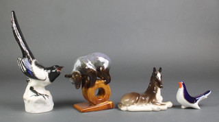 A Russian figure of a bear standing on a wheel 5 1/2", 2 Russian figures of birds and a reclining foal 