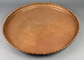 A Middle Eastern circular copper charger with pie crust edge 24" diam. 