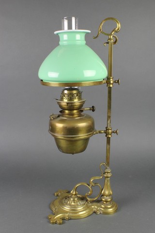 An Art Nouveau brass adjustable oil lamp with opaque green glass shade and chimney 