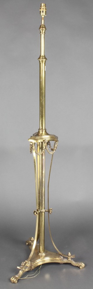 A 19th Century Adam style brass adjustable standard lamp with triform base and paw feet 