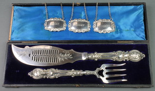 A cased pair of Edwardian silver plated fish servers, 3 spirit labels 
