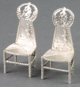 A pair of Continental silver miniature chairs with repousse decoration depicting a fisherman 