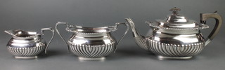 A silver plated 3 piece tea set with demi-fluted decoration, gadroon and shell rims with ebony mounts 