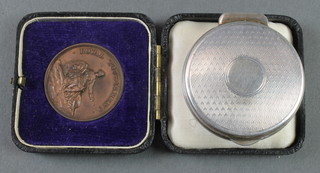 A silver engine turned pill box Birmingham 1913 28 grams and a cased bronze Royal Tournament medal 
