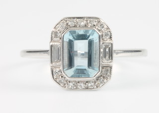 A white gold aquamarine and diamond Art Deco style ring, the centre baguette cut stone enclosed by 14 brilliant cut diamonds, size L 1/2