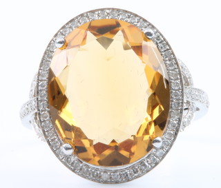 A 14ct white gold citrine and diamond cluster ring, the centre stone 9ct, surrounded by approx 0.75 diamonds, size M 1/2