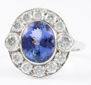 An 18ct white gold tanzanite and diamond cluster ring, the oval cut tanzanite approx. 2.60ct surrounded by 12 brilliant cut diamonds approx. 1.4ct, size P