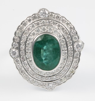 An 18ct white gold oval emerald and diamond cocktail ring, size Q