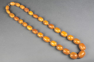 A good single row amber necklace of 29 graduated butterscotch coloured barrel and flattened barrel beads, overall length 88cm, length of longest bead 3.5cm, length of smallest bead 2cm