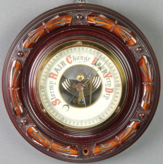 An aneroid barometer with enamelled dial contained in a carved mahogany case 7" 