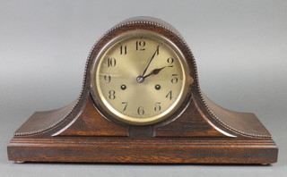 An Art Deco 8 day striking mantel clock with silvered dial and Arabic numerals contained in an oak Admiral's hat shaped case 